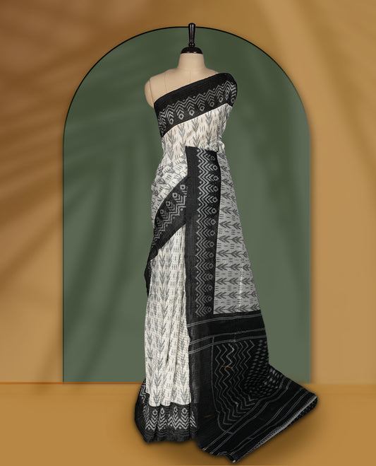 Classic off white colour saree adorned with intricate black tribal motifs and rich woven patterns on the pallu and border & Paired with matching blouse.