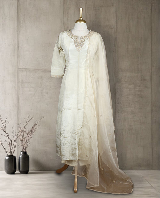 Beige colour salwar from TWARA, featuring a delicate embroidered neck with floral thread work, all over golden style embroidery on the top, paired with a matching bottom and an elegant dupatta.