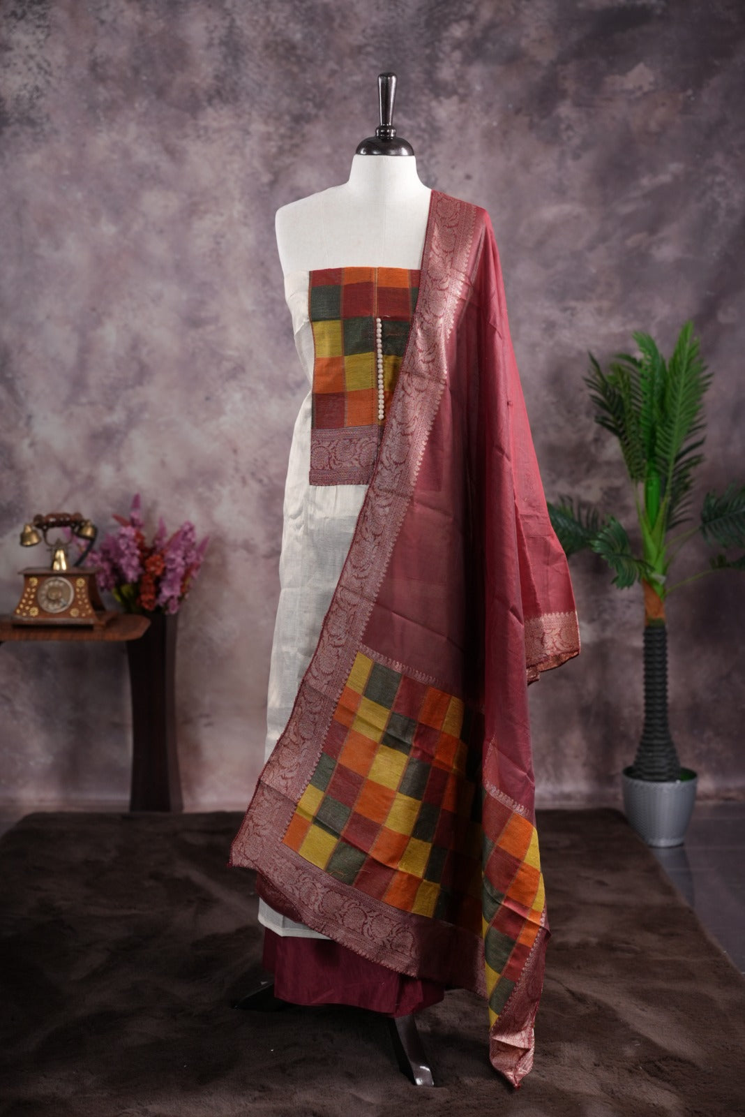 Maroon colour tissue Madras check salwar material featuring a plain body with a classic Kasavu border, paired with a Chanderi dupatta adorned with a matching Kasavu border and a Shantoon fabric bottom.