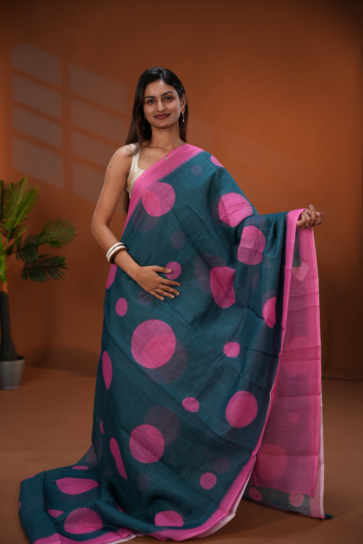 Teal Green colour Linen saree featuring Pink Polka dot on body, Contrast Border and Blouse.