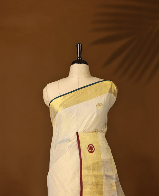 Elegant handloom soft tissue kerala saree. Featuring a cream base with gold zari, maroon , green borders & woven motifs, and paired with a matching blouse, perfect for festivities