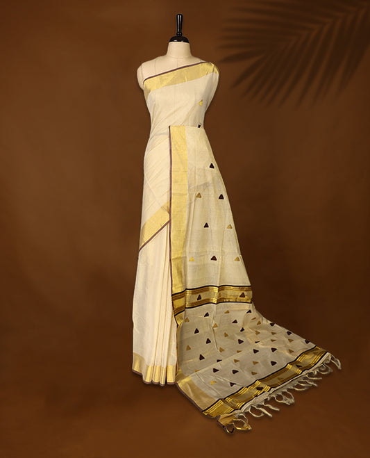 Elegant pure handloom soft tissue kerala saree adorned with small golden and brown triangle motifs, featuring a shimmering golden zari border and pallu, and paired with matching blouse, perfect for festivities.