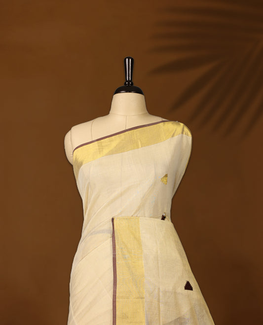 Elegant pure handloom soft tissue kerala saree adorned with small golden and brown triangle motifs, featuring a shimmering golden zari border and pallu, and paired with matching blouse, perfect for festivities.