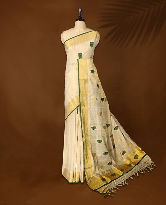 Elegant handloom soft tissue Kerala saree,Featuring a cream base with gold zari, green borders & lotus motifs, and paired with a matching blouse, perfect for festive and traditional occasions.