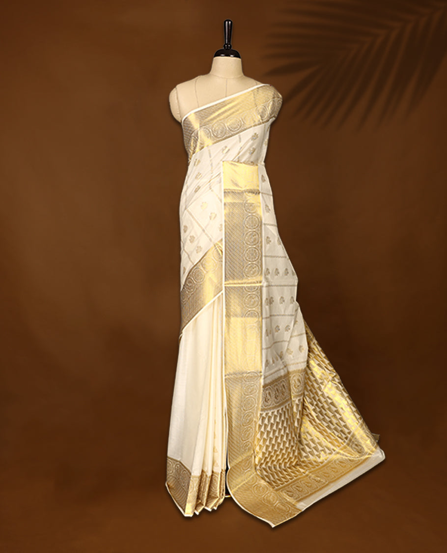 Elegant cotton Kerala saree in cream, adorned with rich gold zari work and traditional floral motifs.,The intricate pallu and broad border add elegance, Paired with a matching blouse, ideal for festive occasions.