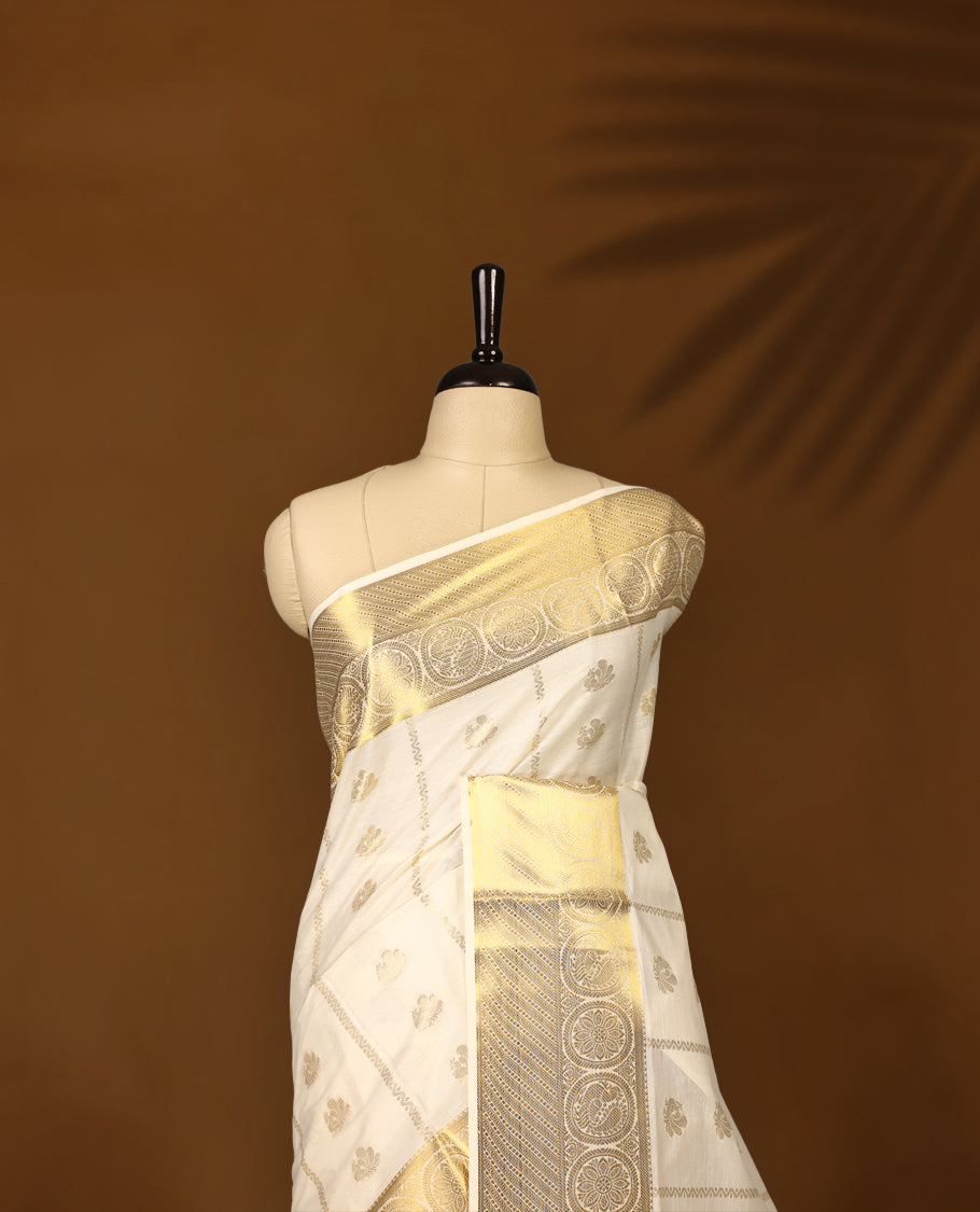 Elegant cotton Kerala saree in cream, adorned with rich gold zari work and traditional floral motifs.,The intricate pallu and broad border add elegance, Paired with a matching blouse, ideal for festive occasions.