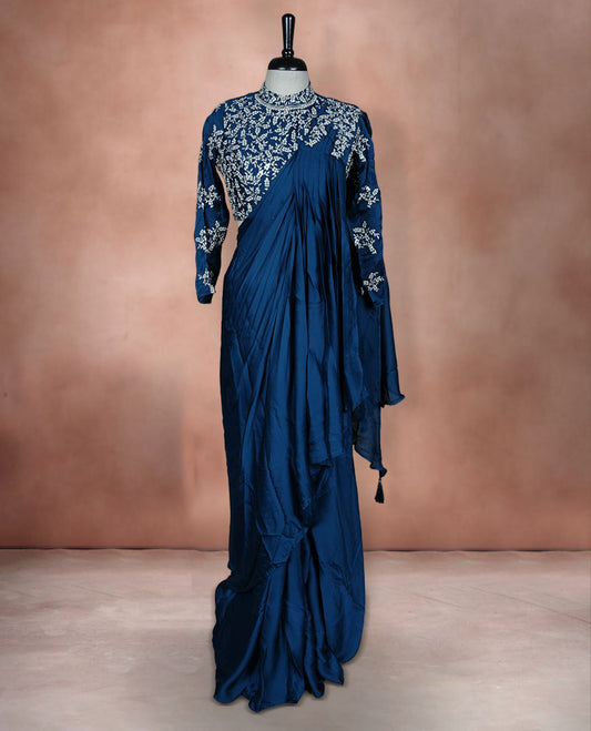 Deep teal colour ready to wear saree Fearturing intricate silver embroidery on the pallu, paired with a beats and thread embroidered matching blouse.