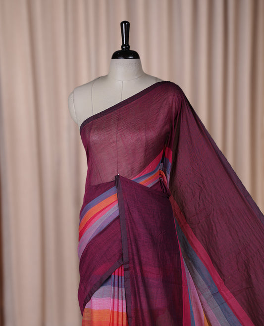 Wine colour soft cotton saree with rainbow colored horizontal lines on the body, a vibrant multicolor pallu, and a subtle border & Elegant and lightweight, this saree comes without a blouse piece for a customizable style.