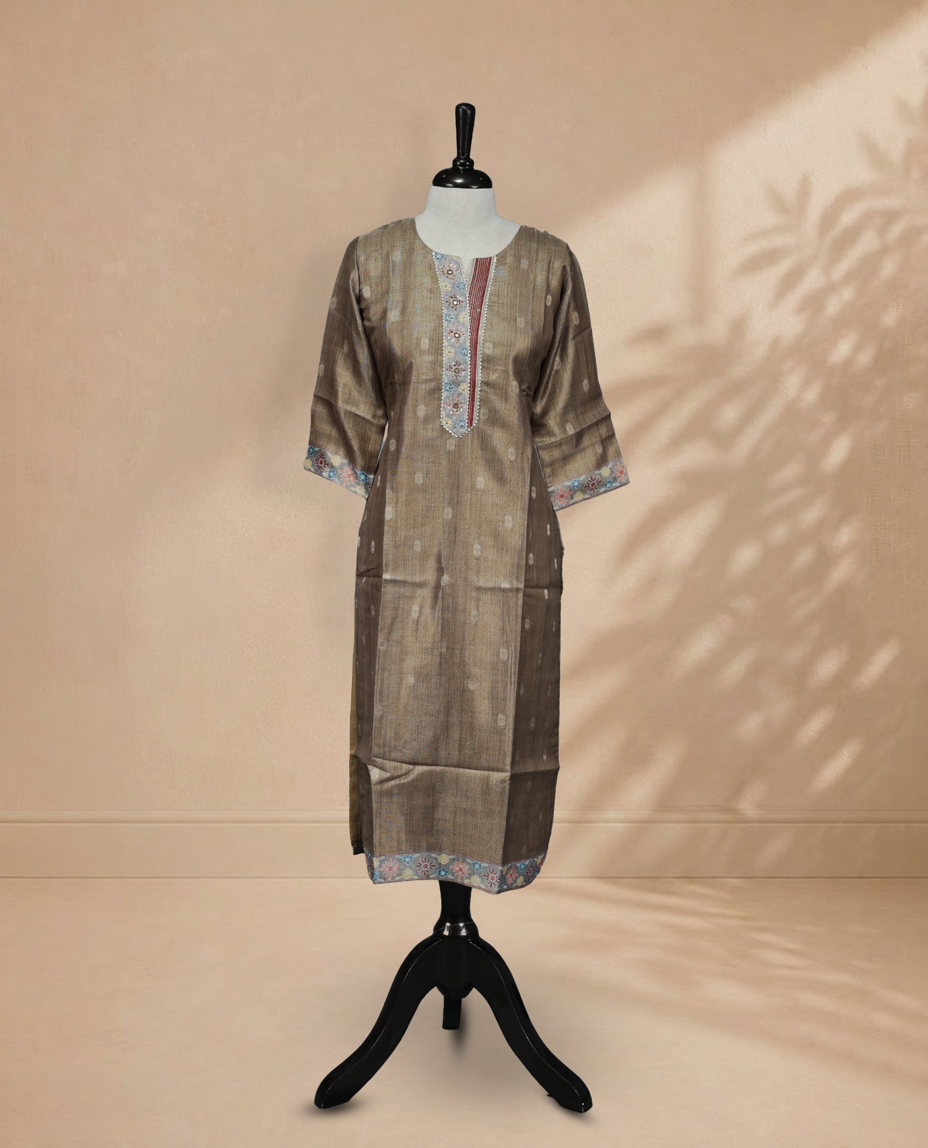 Khaki-colored tissue Kurti featuring gold circle motifs on the body, a U-shaped neckline adorned with thread and bead detailing, and 3/4 sleeves.