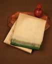 Cream colour tussar saree featuring elegant plain body, contrast Green colour gold zari border and comes with matching blouse piece.