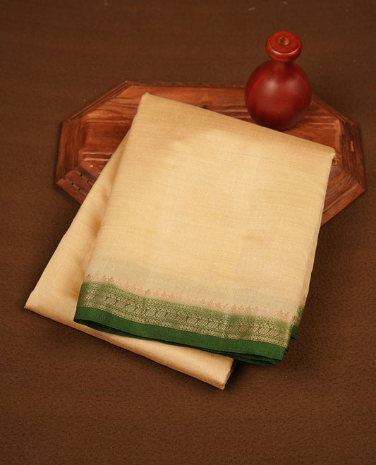 Cream colour tussar saree featuring elegant plain body, contrast Green colour gold zari border and comes with matching blouse piece.