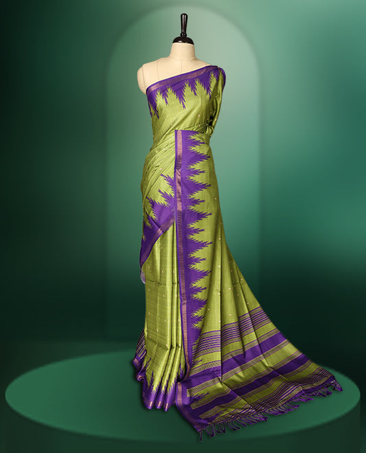Green colour saree adorned with subtle woven motifs on the body, enhanced with a striking Purple Temple patterned border, complemented by a rich Purple striped pallu with tassels, and paired with a matching blouse