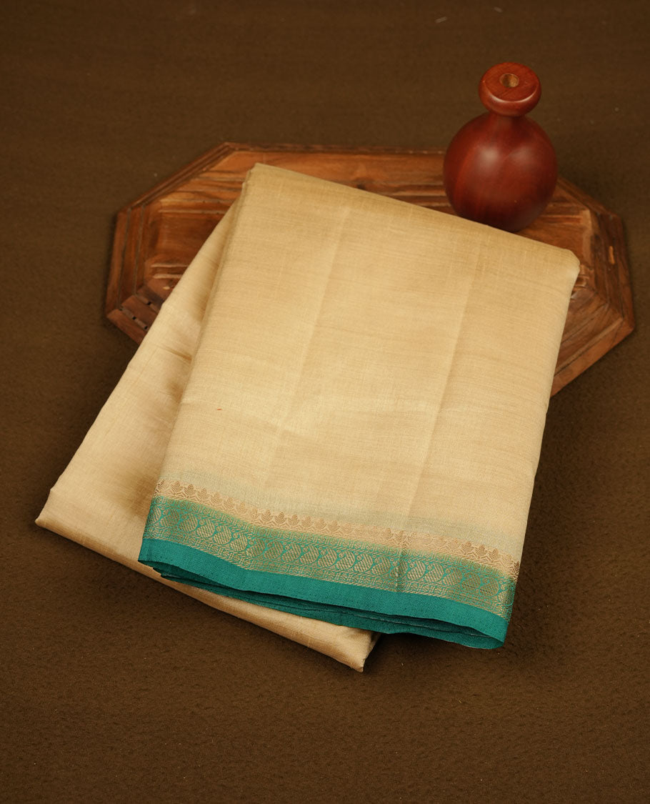 Cream colour semi tussar saree featuring elegant plain body, contrast Green colour gold zari border and comes with matching blouse piece.