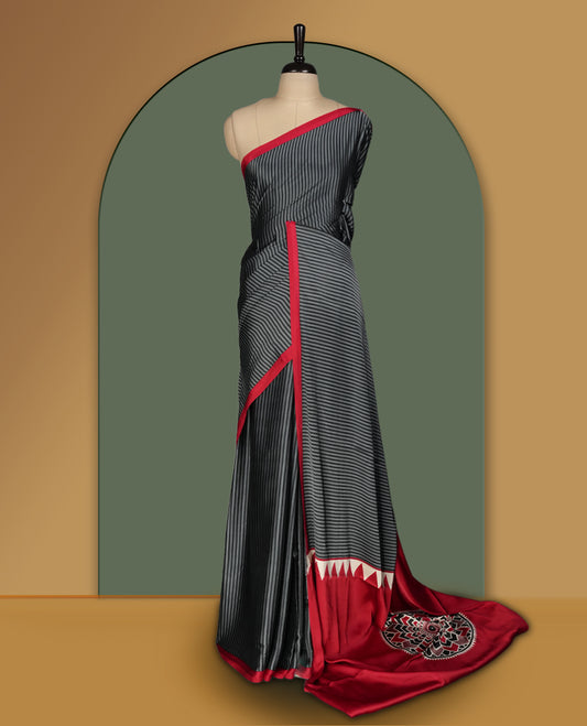 Black colour striped saree highlighted with a bold maroon border, featuring a striking pallu adorned with off white triangular patterns and intricate mandala style embroidery & Paired with a matching blouse.