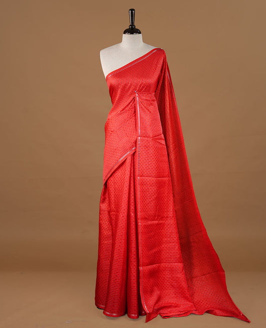 Red colour Semi Tussar saree featuring an elegant zari fancy check pattern on the body, highlighted with a small border for a refined look. Comes without a blouse piece.