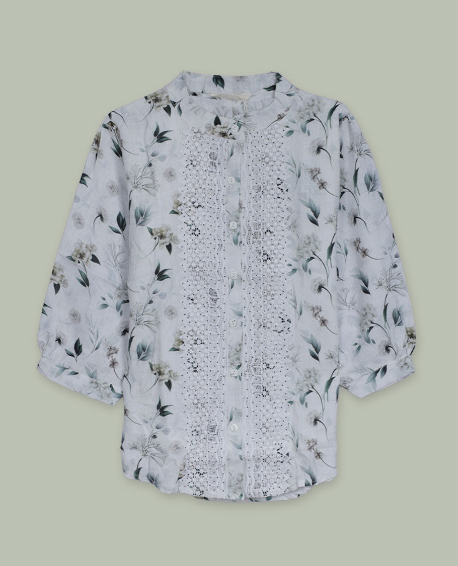 White floral printed shirt top with band collar, three-quarter sleeves, and front button placket framed by intricate lace and pintuck detailing.