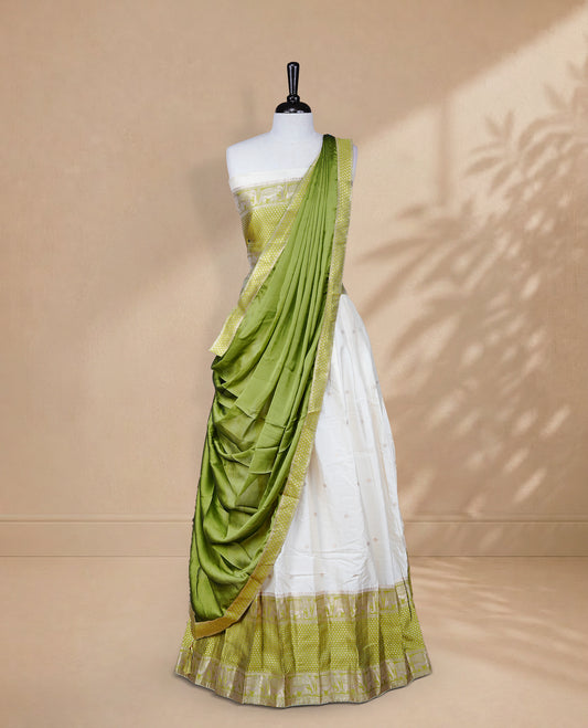 Cream colour Half saree featuring Gold zari buttas on skirt with Zari border on contrast Green colour border, Unstitched Blouse and matching dupatta.