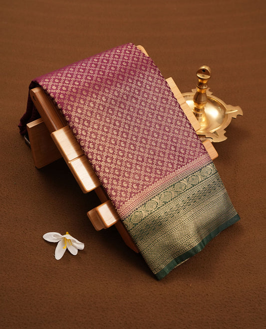 Grape Purple colour semi silk brocade saree featuring intricate Gold Floral kodi & leaf patterns across the body, complemented by a contrast green colour woven border and pallu, paired with a matching blouse.