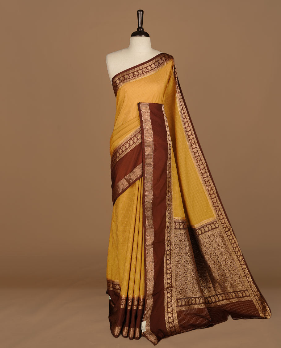 Yellow colour semi georgette saree featuring gold zari check pattern on body, complemented by contrast chocolate colour with zari border, paired with matching blouse piece.