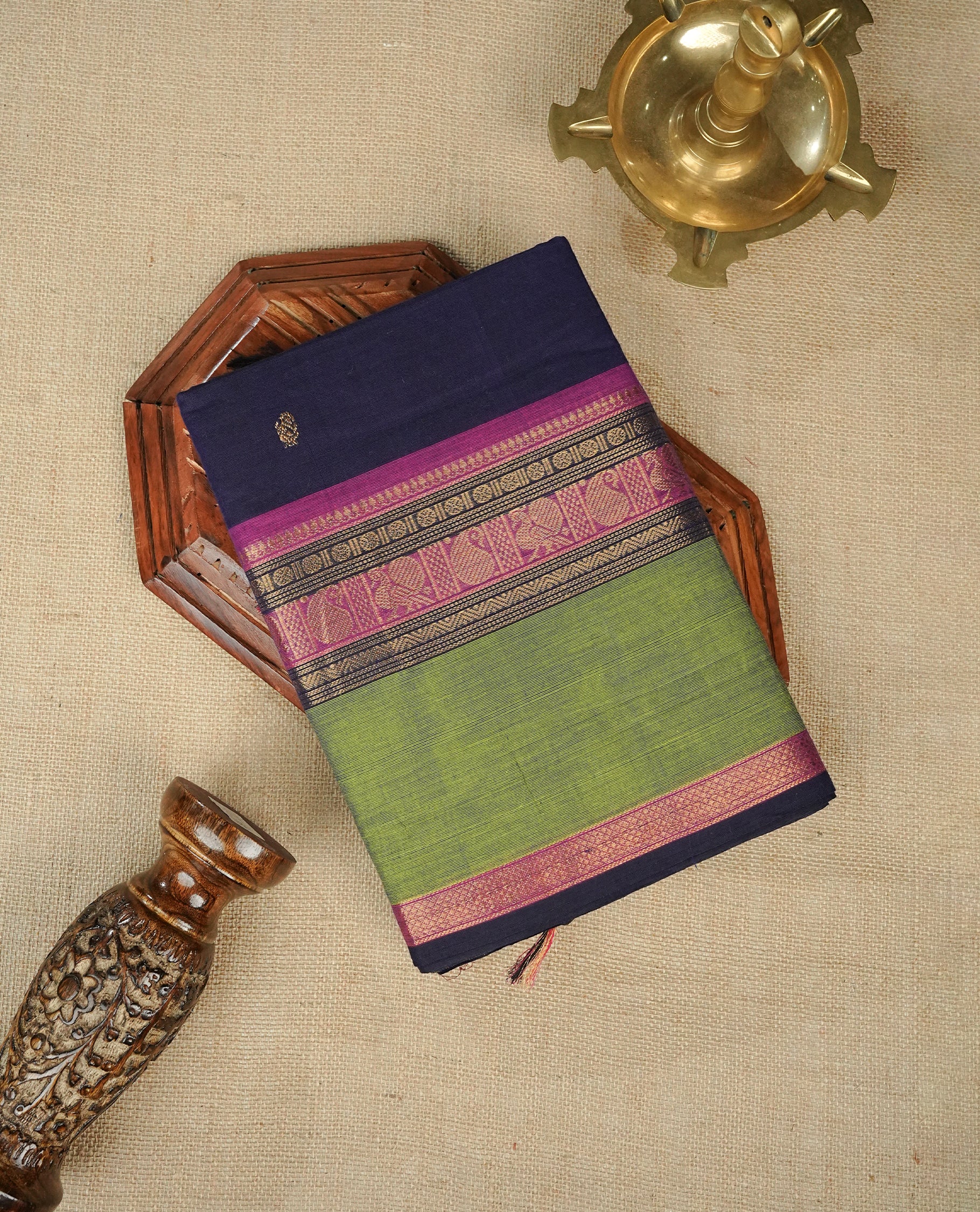Navy blue colour chettinad cotton saree featuring gold zari motifs on body, complemented by contrast green & magenta with gold zari border, comes with matching blouse piece.