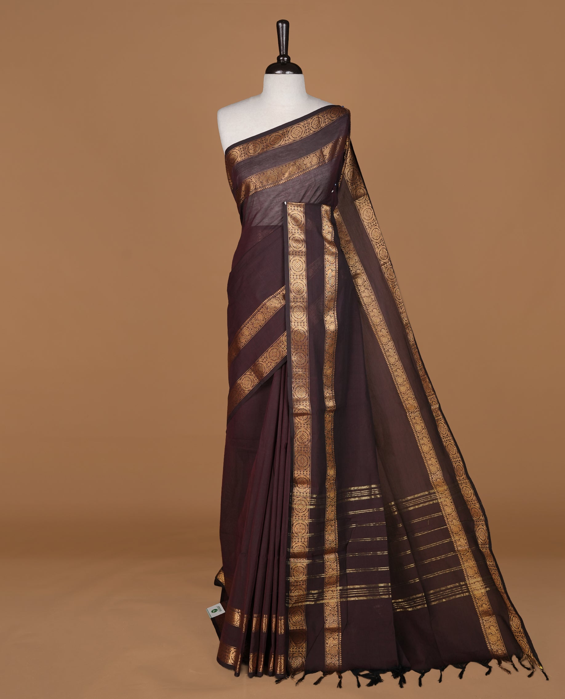 Dark chocolate colour Chettinad cotton saree featuring Elegant plain body, complemented by self colour with gold zari border, paired with matching blouse piece.