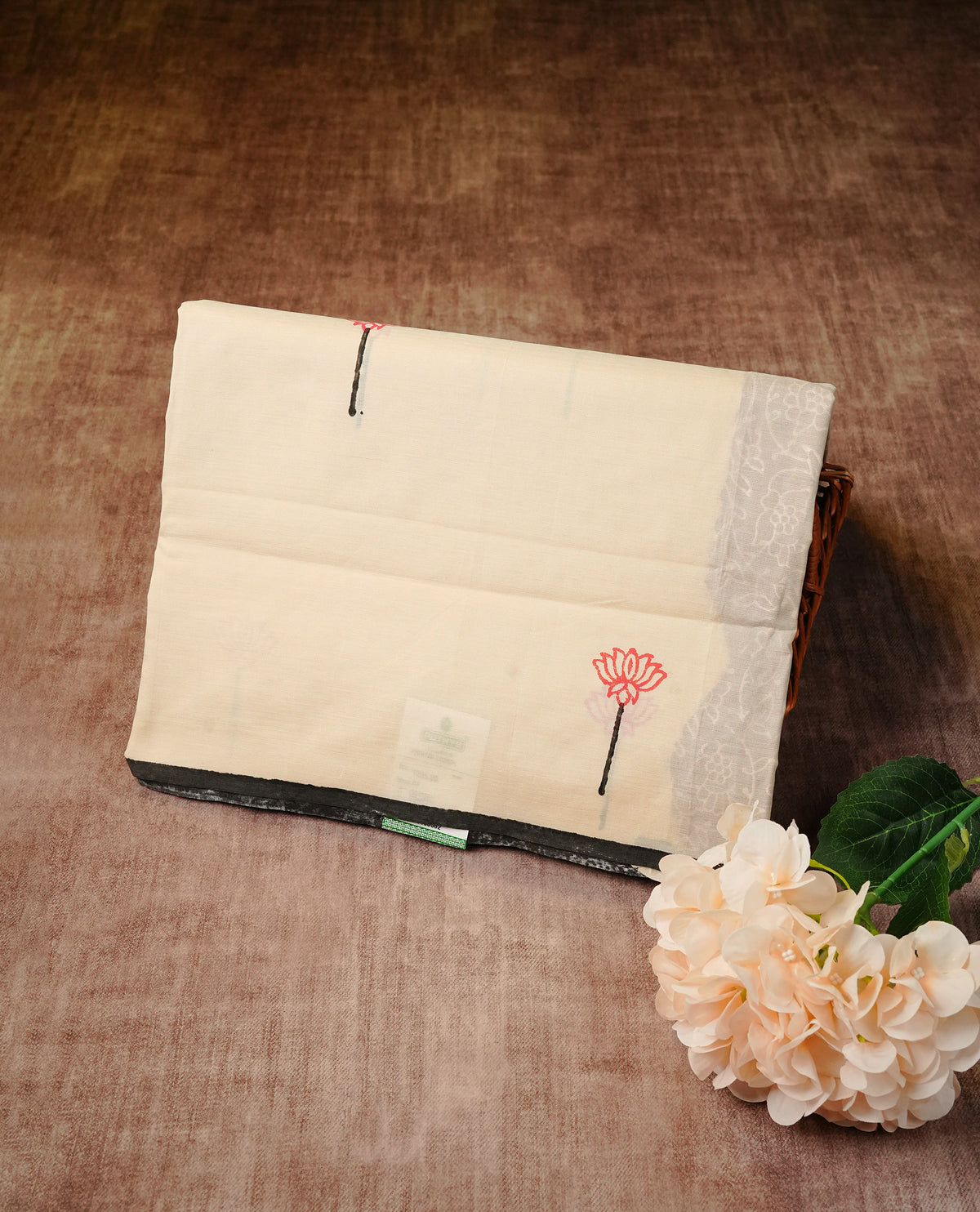 Cream colour Polycotton Saree adorned with delicate lotus motifs across the body and pallu, creating a graceful and minimalist look. Finished with a subtle black border and paired with a matching printed blouse piece,