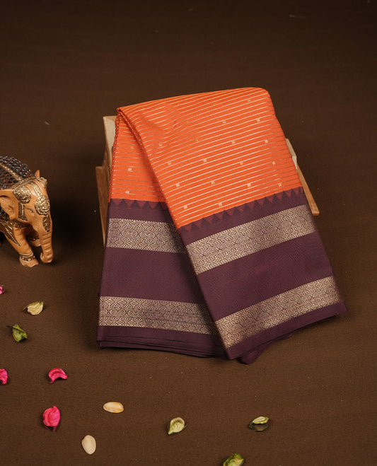 Rust orange colour semi silk saree featuring gold zari stripes small motifs on body highlighting contrast dark chocolate gold zari floral chakra border , paired with matching blouse