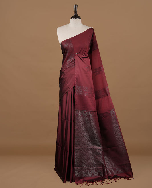 Maroon soft silk saree features a sleek borderless design with intricate antique zari motifs, flowing into a seamless self colored pallu and a matching blouse piece.