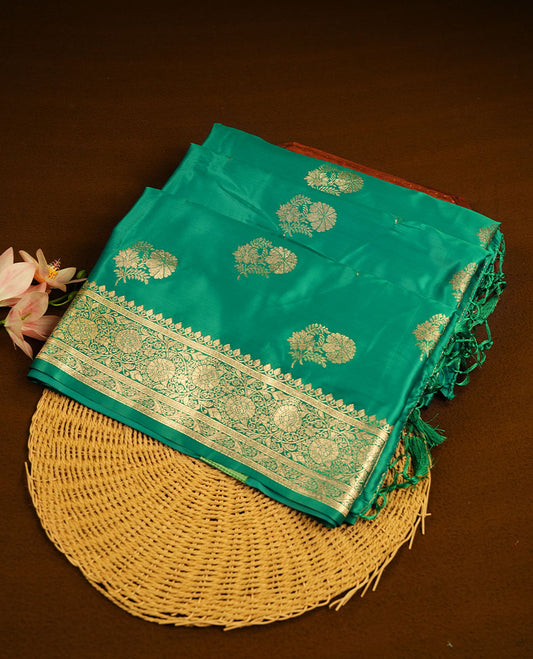 Green colour Banaras Satin Crepe saree featuring gold zari floral motifs on the body, a richly woven traditional border with intricate gold zari detailing, and paired with a matching blouse.