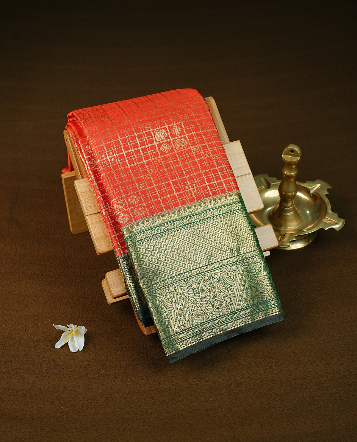 Rust orange colour semi wedding saree featuring gold zari check with peacocok motifs on body complemented by contrast green colour with traditional border, comes with macthing blouse piece.