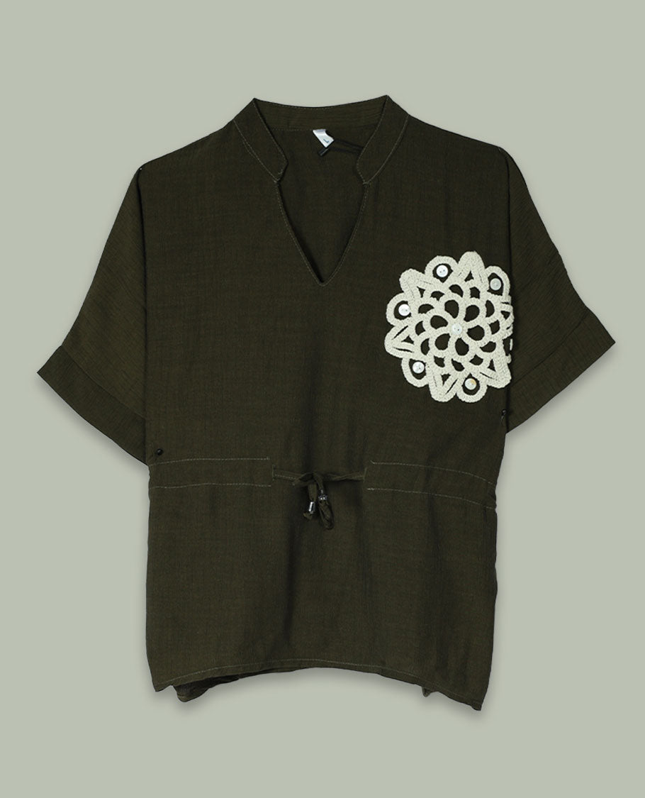 Olive green short-sleeve top with V-slit band neckline, contrast ivory crochet motif on one side, and adjustable drawstring detail at the waist.
