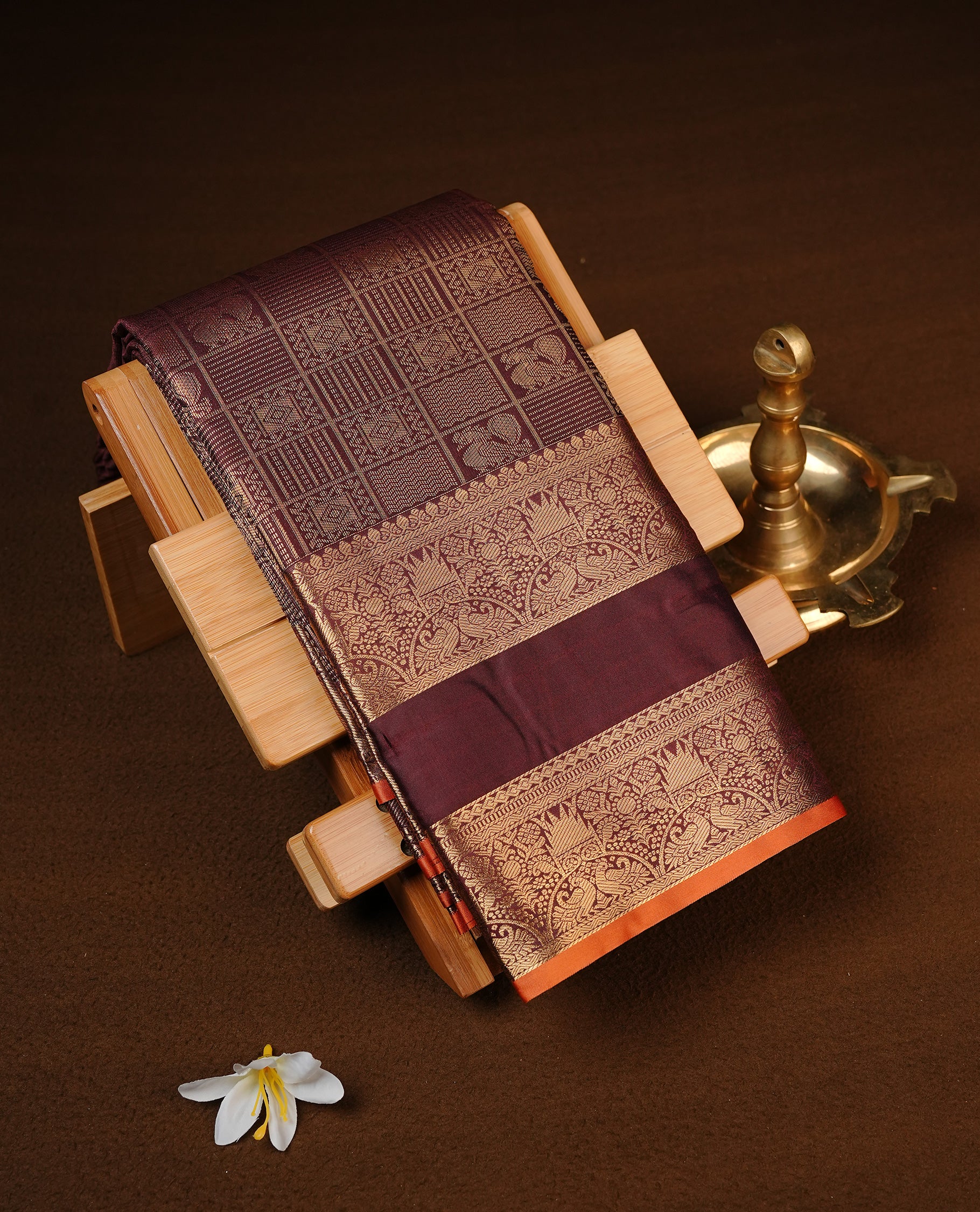 Chocolate Brown Colour Semi Wedding Silk Saree Featuring Gold Zari Checks With Buttas, Showcased with self colour Orange pipping With Traditional Border,  Paired With Matching Blouse Piece.