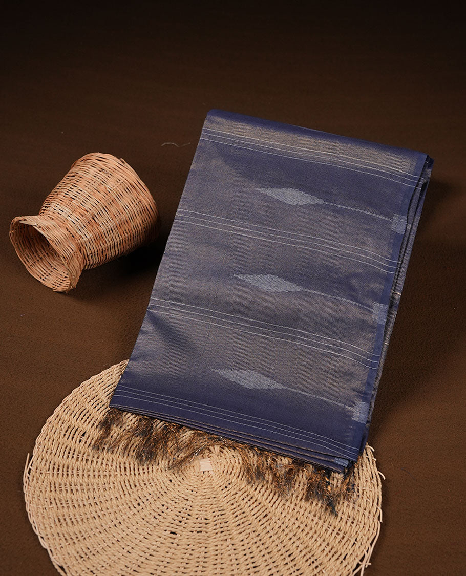 Dark blue colour semi jute saree highlighting gold zari stripped body with white motifs, without border and paired with matching blouse.