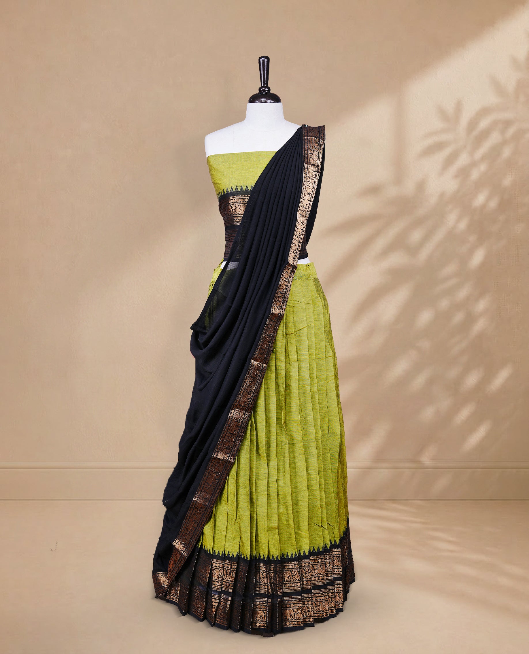 Olive green colour Half saree featuring Plain skirt with Zari border on contrast black colour border, Unstitched Blouse and matching dupatta.