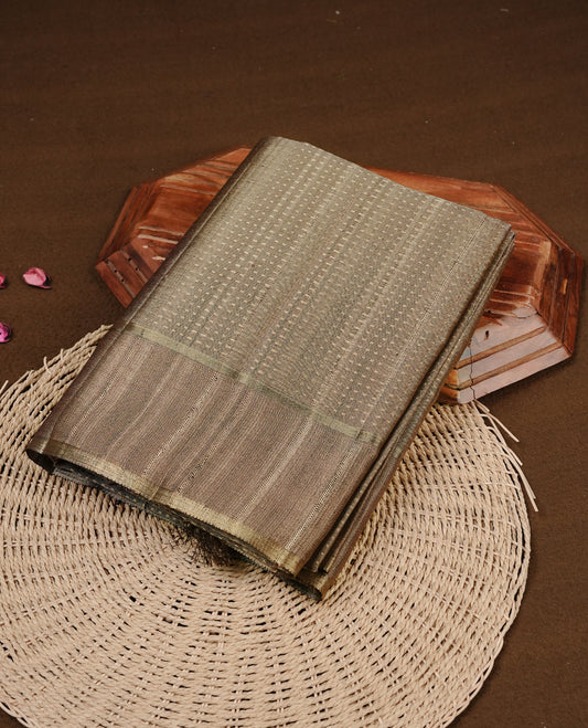 Antique gold colour semi tussar silk saree featuring elegant gold zari dotted stripes across the body, enhanced with a rich zari woven border. Comes with a matching blouse piece.