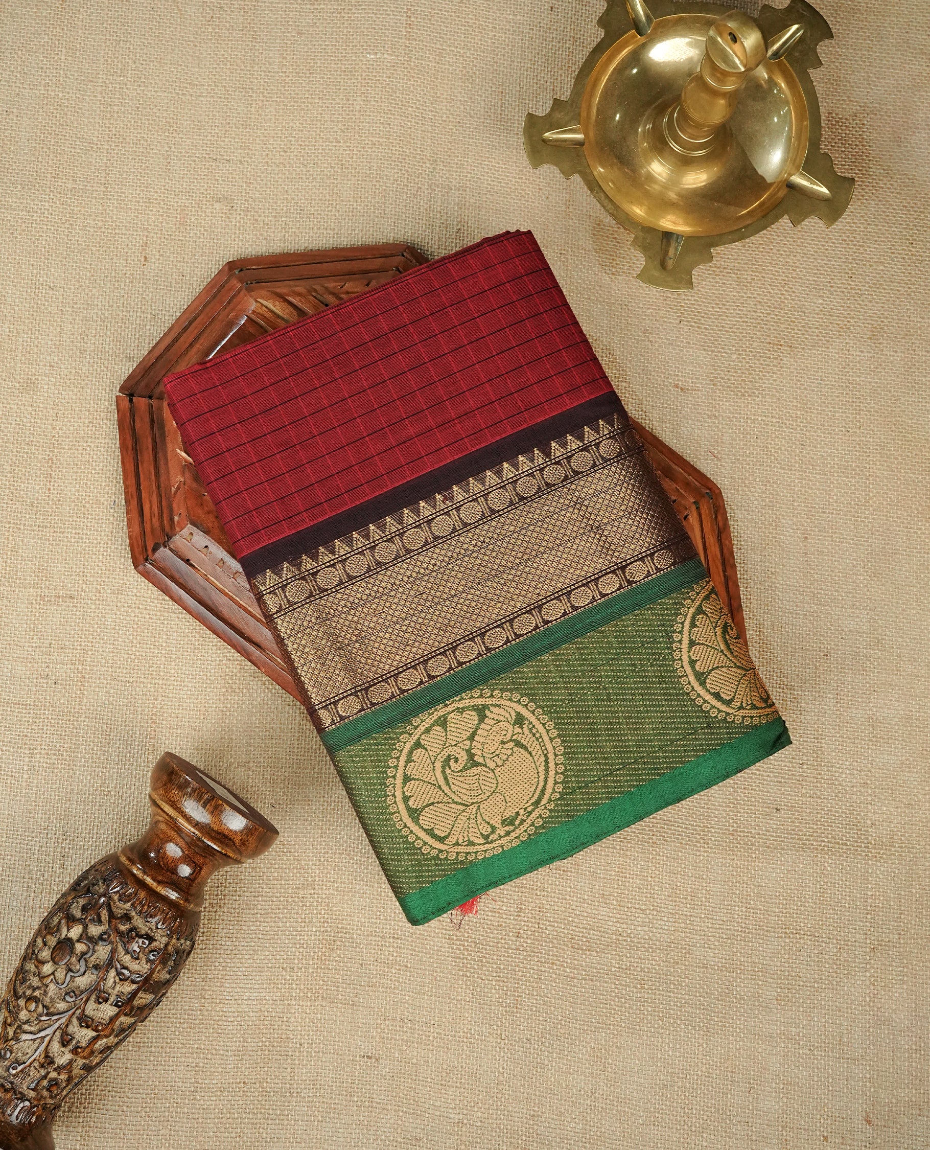 Maroon colour chettinad cotton saree featuring Check pattern on body, complemented by Contrast Black & Green Colour with gold zari border, comes with matching blouse piece.