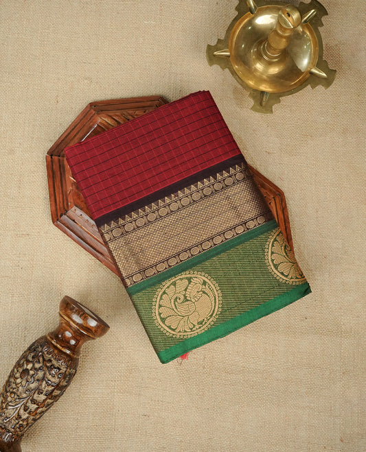 Maroon colour chettinad cotton saree featuring Check pattern on body, complemented by Contrast Black & Green Colour with gold zari border, comes with matching blouse piece.