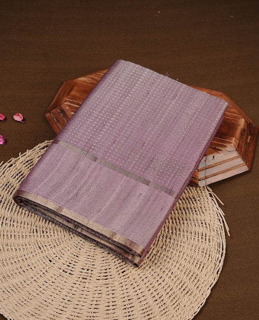 Lavender colour semi tussar silk saree featuring elegant gold zari dotted stripes across the body, enhanced with a rich zari woven border. Comes with a matching blouse piece.