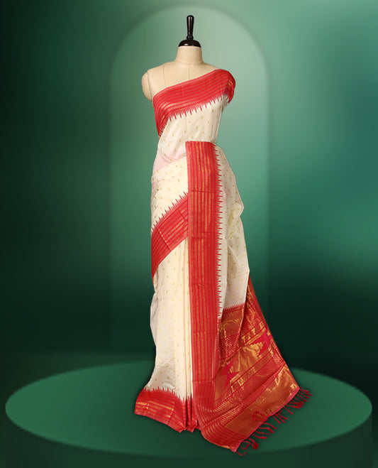 off white colour saree adorned with delicate golden motifs, accentuated by a vibrant red border with intricate weaving, and a rich red gold zari pallu, paired with a matching blouse