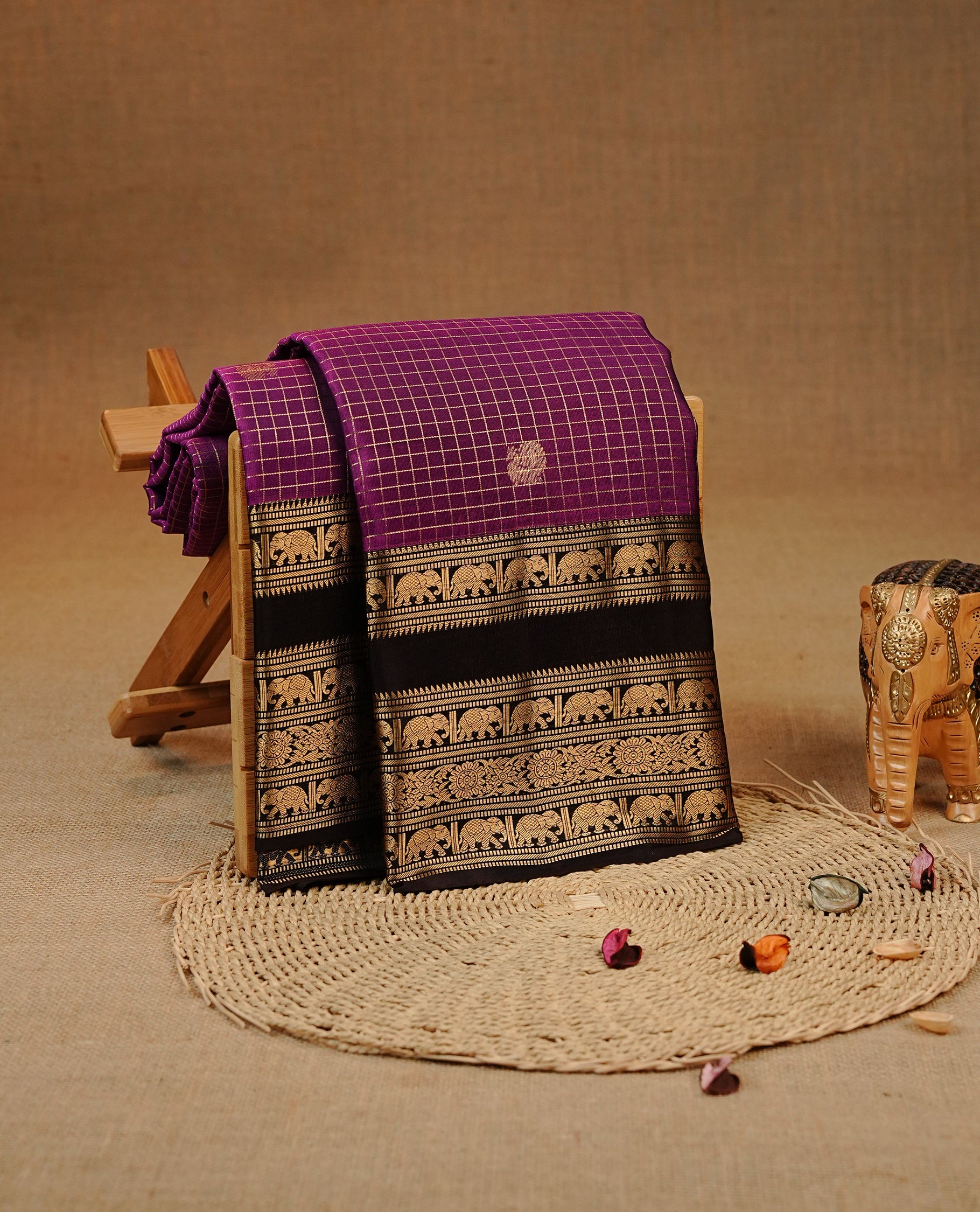 Purple colour Kancheepuram silk saree featuring Gold zari check with Chakra Motifs on body, complemented by chocolate colour with Traditional border, comes with matching blouse piece.