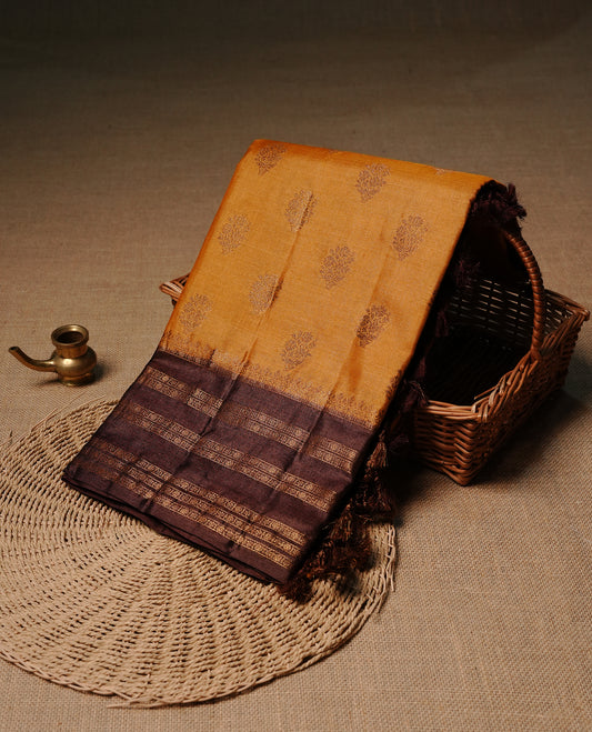 Mustard colour pure tussar banaras silk saree featuring gold zari motifs on body, highlighting contrast Chocolate colour with zari border, paired with matching blouse piece.
