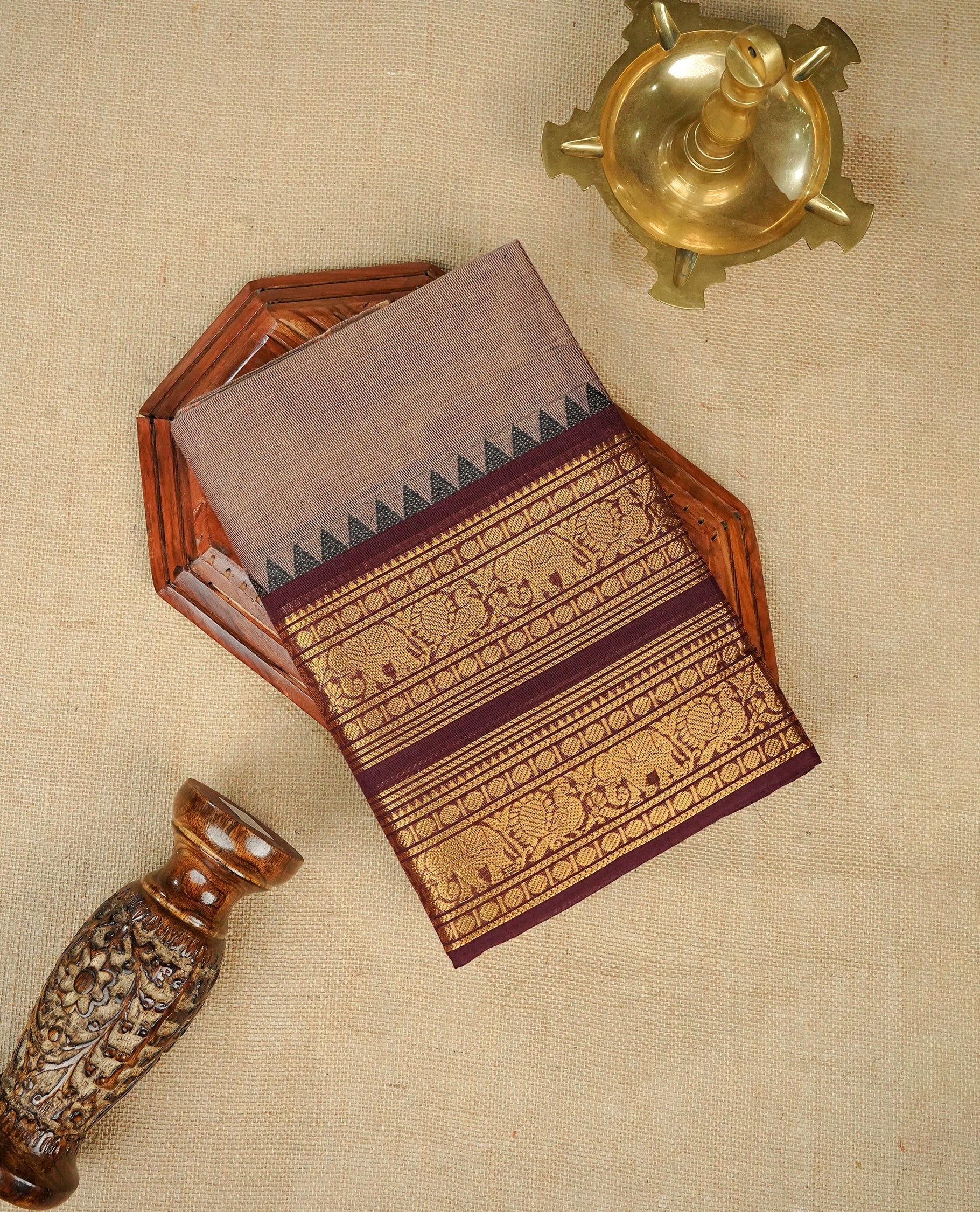 Grey colour chettinad cotton saree featuring Elegant plain body, complemented by contrast maroon colour with gold zari border, comes with matching blouse piece.