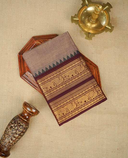 Grey colour chettinad cotton saree featuring Elegant plain body, complemented by contrast maroon colour with gold zari border, comes with matching blouse piece.