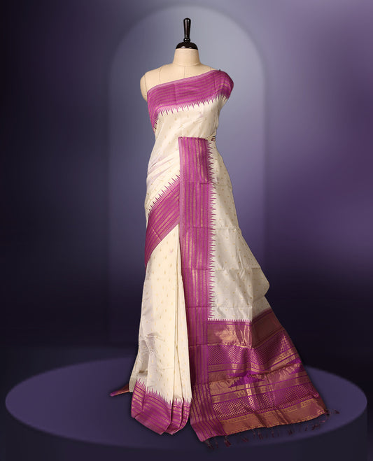 Off white colour saree adorned with delicate golden motifs, accentuated by a vibrant magenta border with intricate weaving, and a rich magenta gold zari pallu, paired with a matching blouse.