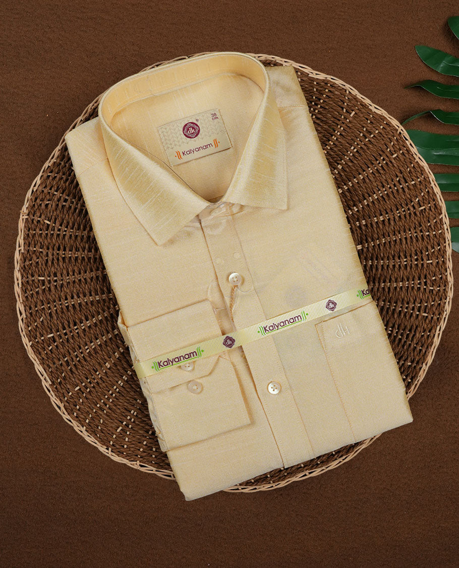 Golden beige DH men’s shirt featuring a glossy silk finish with self textured weave, full sleeves, classic collar, and chest pocket ideal for weddings and traditional functions