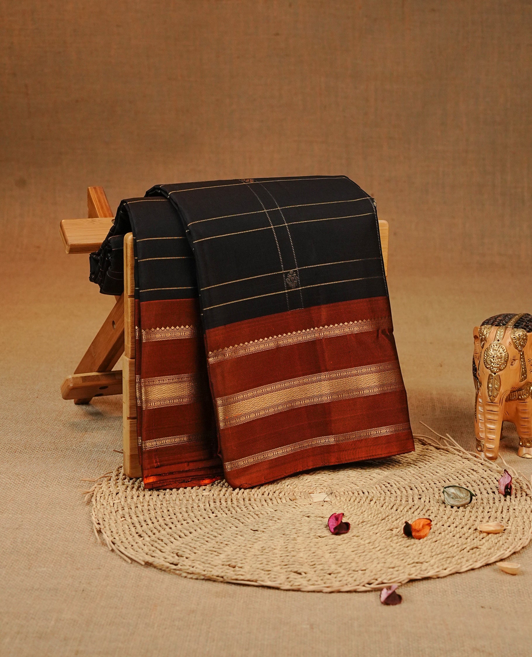 Black colour Kancheepuram silk saree featuring Gold zari check with Chakra Motifs on body, complemented by Rudt orange colour with Traditional border, comes with matching blouse piece.