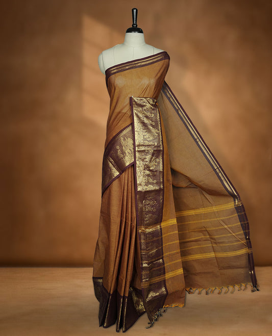 Mustard colour chettinad cotton saree featuring plain body, contrast chocolate brown colour with traditional gold zari border paired with matching blouse.
