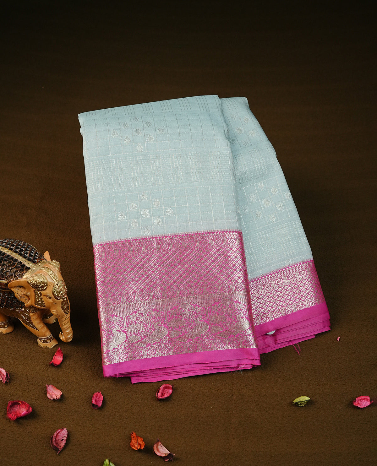 Silver grey colour semi wedding silk saree featuring silver zari checks with motifs on body,contrast magenta pink colour with peacock traditional border on body, rich pallu comes with matching blouse piece