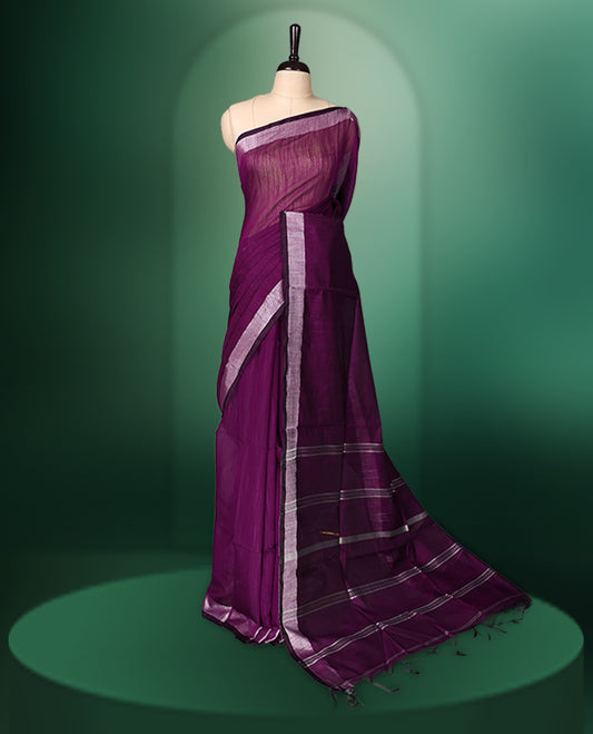 Deep plum colour handloom cotton saree featuring a solid body with a contrasting silver zari border and subtle striped pallu, paired with a matching blouse