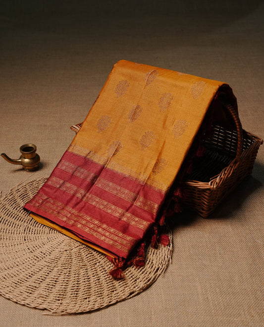 Mustard colour pure tussar banaras silk saree featuring gold zari motifs on body, highlighting contrast Maroon colour with zari border, paired with matching blouse piece.
